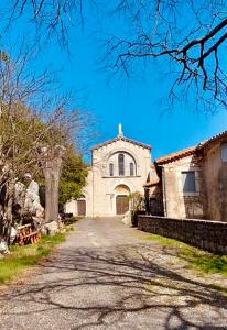 an empty road leading to a white church at Gîte de charme au pied du Château de Brissac in Brissac +21 photos