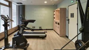 a gym with a treadmill and a bike in a room at Campanile PRIME - Nanterre La Défense in Nanterre