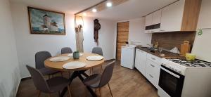 a kitchen with a wooden table and a table and chairs at KONAK in Pleternica
