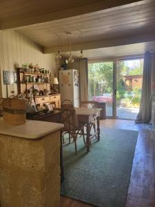 a kitchen and dining room with a table and a refrigerator at Échoppe Saint Augustin in Bordeaux