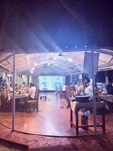 a group of people sitting at tables in a restaurant at Samant Beach Resort in Malvan