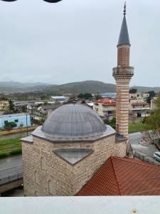 a brick building with a tower and a mosque at Redi Apartment Center in Elbasan