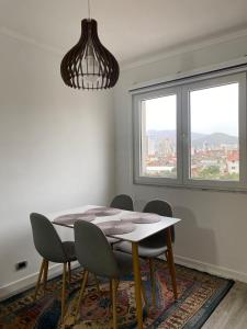 a dining room with a table and chairs and a window at Redi Apartment Center in Elbasan +9 photos