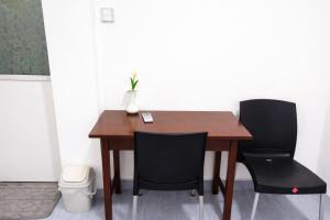 a wooden table with two chairs and a vase on it at Robert's-stay in Katunayaka