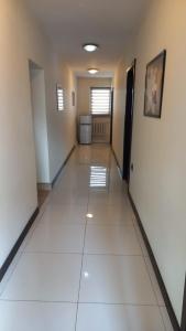 a long hallway with white tile floors and a room at Usługi Hotelarskie Jan in Ząbki
