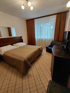 a bedroom with a bed and a couch and a television at Usługi Hotelarskie Jan in Ząbki