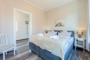 ein Schlafzimmer mit einem blauen Bett und einem Stuhl in der Unterkunft Hafencity Apartments in Tönning + 15 Fotos