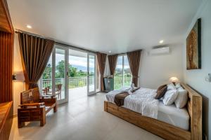 a bedroom with a large bed and a balcony at Hayana Villa Kintamani in Gretek