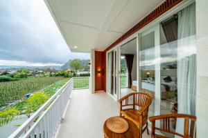 a balcony with a table and chairs and a view at Hayana Villa Kintamani in Gretek