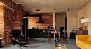 a living room with a brick wall and a table and chairs at hellofrom Tobacco Warehouse in Kavála