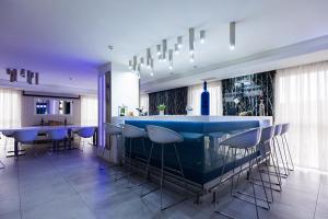 a kitchen with a blue bar with stools at Rox in Modriča