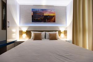 a bedroom with a large white bed with two pillows at Rox in Modriča