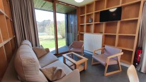 a living room with a couch and two chairs and a television at Les Woodies in Xertigny +40 photos