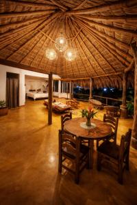 a room with a table and chairs and a large ceiling at Villa Luna de Miel in Mazunte