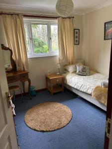 a bedroom with a bed and a window and a rug at Craigie dhu, guest house in Colliston