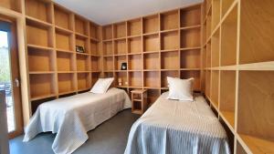 two beds in a room with wooden shelves at Les Woodies in Xertigny