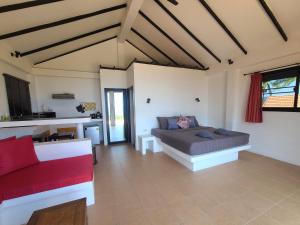 a living room with a bed and a red couch at Karo Villas in Ko Tao