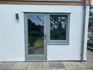a door with a window on a white house at Timbers in Truro +4 photos