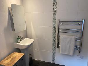 a white bathroom with a sink and a mirror at Timbers in Truro