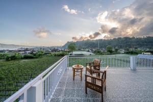 a balcony with two chairs and a table at Hayana Villa Kintamani in Gretek