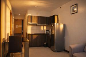 a kitchen with a stainless steel refrigerator and cabinets at Extremeli Suites in Manila