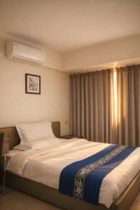 a bedroom with a large bed with a window at Extremeli Suites in Manila