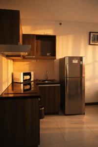a kitchen with a stainless steel refrigerator and a sink at Extremeli Suites in Manila +58 photos