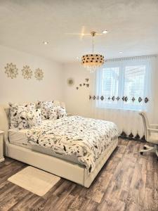 a bedroom with a bed and a chandelier at Vila Vannet II in Liptovský Mikuláš