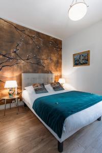 a bedroom with a bed with a painting on the wall at Le Bretagne - Hôtel de charme labellisé Cosy Places in Vannes