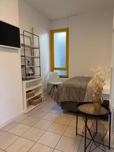 a bedroom with a bed and a table and a tv at NiceStay in Lugano +3 photos