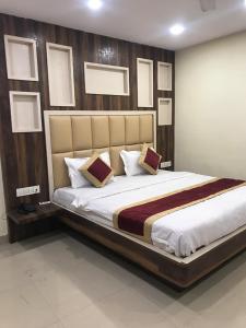 a bedroom with a large bed with a wooden headboard at Hotel Priya Palace in Rānchī