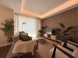 a living room with a couch and a tv at Madeira Bliss II Prime Location with Pool and Parking in Funchal