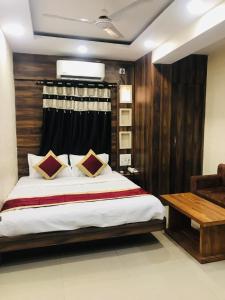 a bedroom with a large bed and a wooden wall at Hotel Priya Palace in Rānchī +13 photos