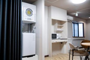 a kitchen with a refrigerator and a table with chairs at Edo stay senju in Tokyo