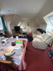a living room with a table and a couch at Craigie dhu, guest house in Colliston