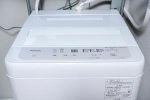 a white washing machine sitting in a room at Edo stay senju in Tokyo