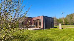 a small black house in a grassy field at Les Woodies in Xertigny