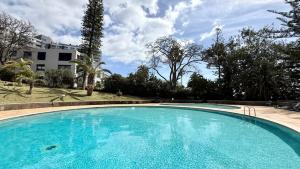 a large blue swimming pool in front of a building at Madeira Bliss II Prime Location with Pool and Parking in Funchal