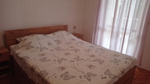 a bed with a comforter with butterflies on it at Apartments D & P in Korčula