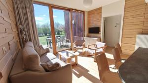a living room with a couch and chairs and a table at Les Woodies in Xertigny