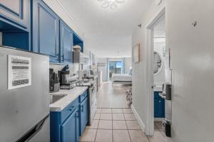 a kitchen with blue cabinets and a white refrigerator at Beach View Condo in Myrtle Beach