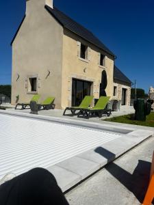 a house with a swimming pool in front of a building at La Maison De Parrain in Kerlouan