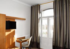 a hotel room with a desk and a window at Hotel Moderne in Arras