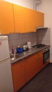 a kitchen with orange cabinets and a stove top oven at Apartments D & P in Korčula +30 photos