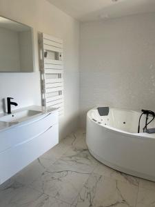 a white bathroom with a tub and a sink at La Maison De Parrain in Kerlouan +20 photos