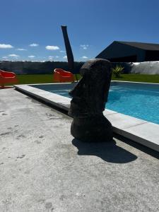 a sculpture is sitting next to a swimming pool at La Maison De Parrain in Kerlouan