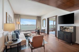 a living room with a couch and a tv at The Oberoi Mumbai in Mumbai