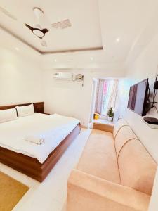 a living room with a bed and a couch at Airport Sky Transit Suites in Rānchī