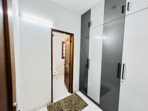 a bathroom with white walls and a doorway with a mirror at Traditional villa in Gurgaon