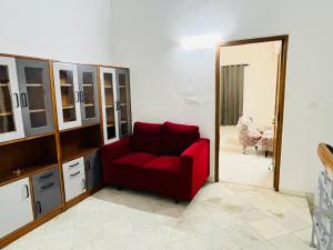 a red chair in a room with a mirror at Traditional villa in Gurgaon